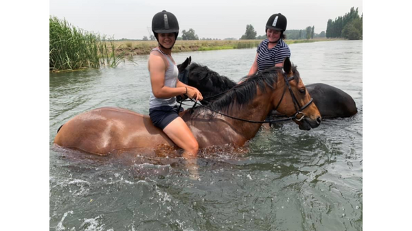 2 horses and riders in river